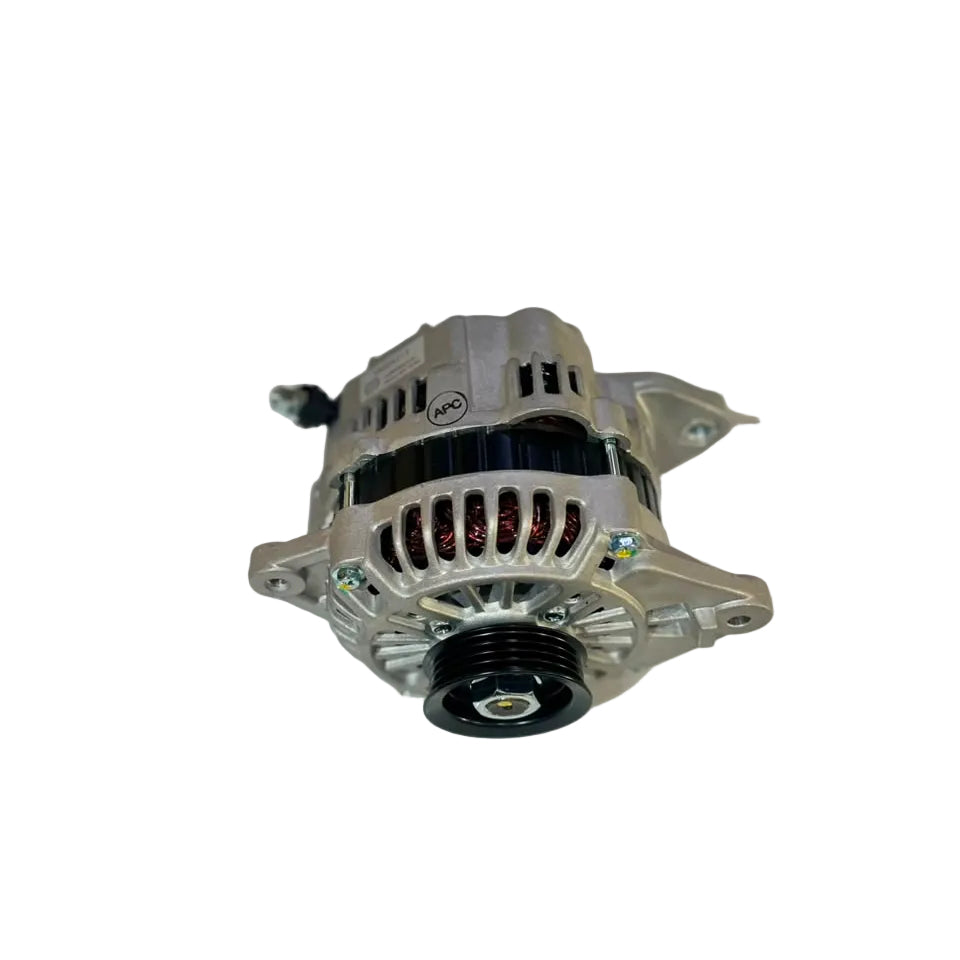 A used automotive alternator with a silver aluminum housing, black pulley, and ribbed black belt cover, resting on a white surface.