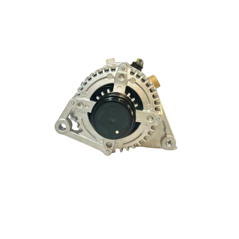 An automotive alternator with a silver aluminum housing and black center, resting on a white surface with a blurred warehouse background.