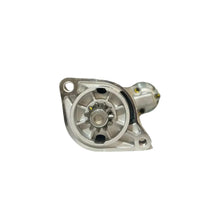A silver metallic automotive part, likely a water pump or alternator component, resting on a white surface with a blurred background of store shelves.