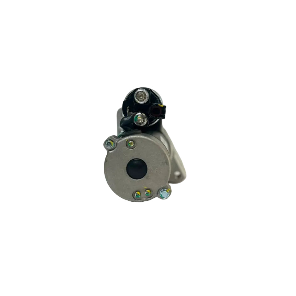 A small cylindrical metal mechanical part with a black connector and several silver screws, photographed on a white surface with a blurred indoor background.