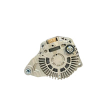 A silver automotive alternator resting on a white surface, with a blurred warehouse or auto parts store background.